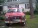 1985 Ford Bronco - This red Ford Bronco is equipped with a front bull bar and auxiliary lights on the roof rack.