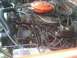 1985 Ford Bronco - A view of the engine bay, an orange air cleaner and numerous spark plug wires.
