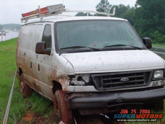 White work van with ladder rack, muddy, front damage