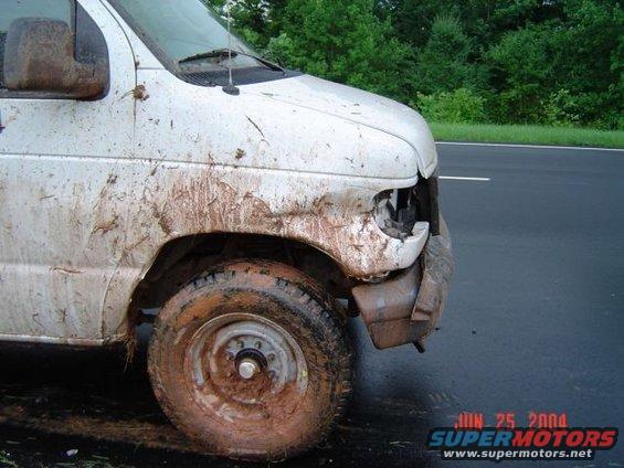 Mud-covered van, front corner damaged, tire caked in mud