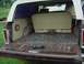 1979 Ford Bronco - The cargo area of a 1979 Ford Bronco shows a folded rear seat and a dumbbell on the floor.