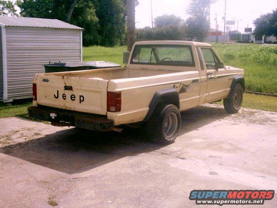 Cream-colored Jeep pickup truck, rear view, with 'JEEP' text on tailgate
