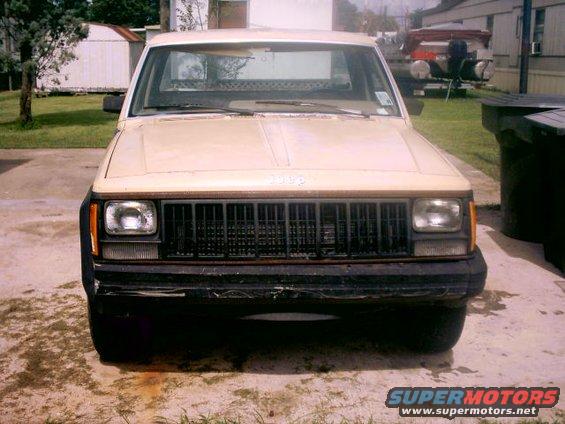 Front view of a tan Jeep Comanche pickup truck with a black grille