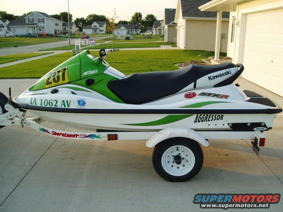 White and green Jet Ski on a trailer, with 'Kawasaki' and 'Aggressor' visible