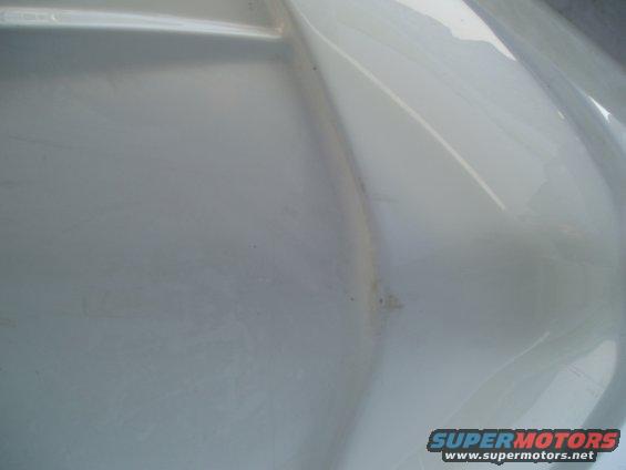 white plastic part with Supermotors.net logo