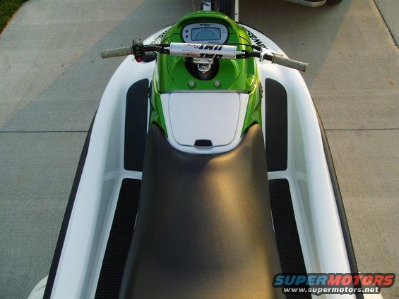 Jet ski with green front and black seat, parked on concrete