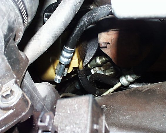 Close-up of hoses and metal parts in a vehicle's engine bay
