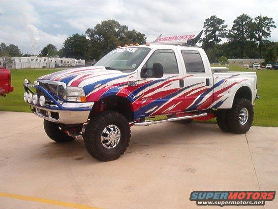 White pickup truck with red, white, and blue flame graphics and "SkyJacker" banner