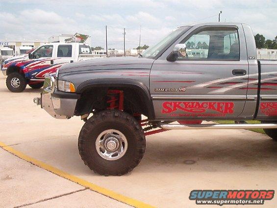 Gray lifted pickup truck with red "SkyJacker" graphics, seen from 3/4 front
