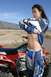 1986 Ford Bronco - A woman adjusts her motocross gear while standing next to a red ATV in a dry, outdoor landscape.