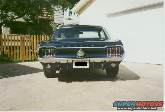 Dark blue 1967 Ford Mustang rear view, chrome bumper, quad exhaust pipes, Minnesota license plate