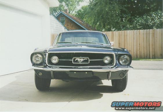 Front view of a dark blue 1967 Ford Mustang with a chrome grille and horse emblem