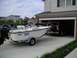 1994 Ford Bronco - A red 1994 Ford Bronco is parked in a garage, partially obscured by a boat on a trailer.