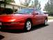 1996 Ford Probe - A red 1996 Ford Probe is shown from the front three-quarter view, parked in a residential area.