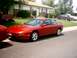 1996 Ford Probe - A red 1996 Ford Probe is parked in a driveway in front of a suburban house.