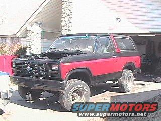 1982 Ford Bronco with hood open, two-tone paint, parked outside