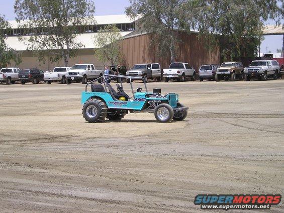 Teal custom dune buggy with large tires and exposed engine