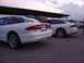1993 Ford Probe - Two white Ford Probe cars are parked in a lot under a covered structure.
