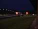 1993 Ford Probe - A drag strip is illuminated by lights and scoreboards at night, with a dark sky overhead.