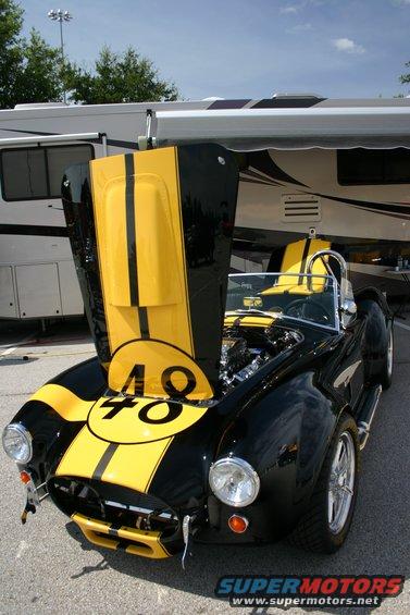 Black and yellow striped convertible with hood open showing engine and number 48