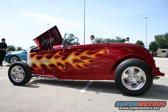 Red hot rod with flame decals, hood open, side view