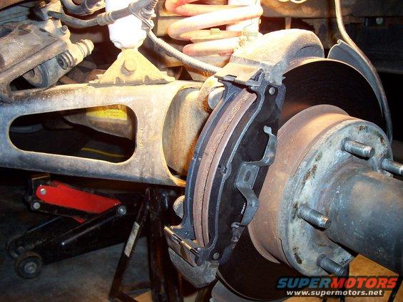 Rear brake caliper and rotor with new brake pads installed