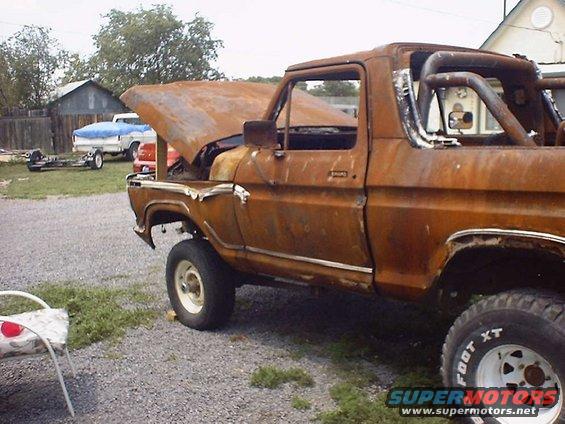 rusted pickup truck with hood open, roll bar in back