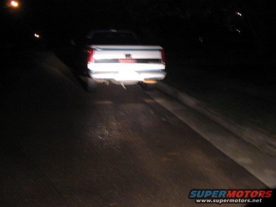 Rear view of a white pickup truck at night