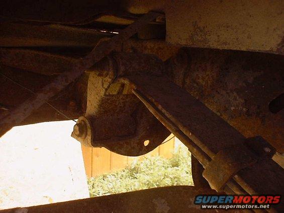 Close-up of heavily rusted leaf spring and suspension bracket on an old vehicle