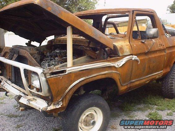 Heavily rusted 1978 Ford pickup truck with hood propped open, showing engine compartment
