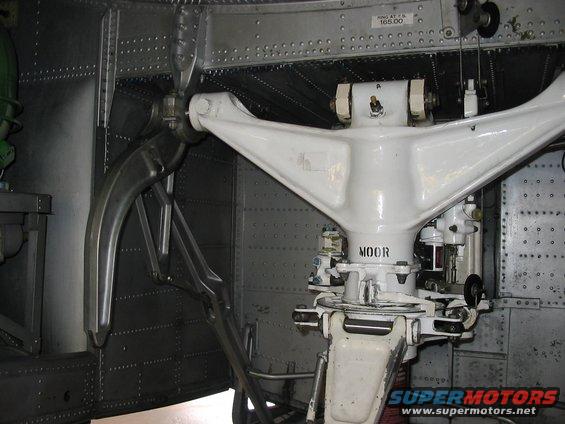 Close-up of a white aircraft landing gear assembly with the word 'MOOR' visible