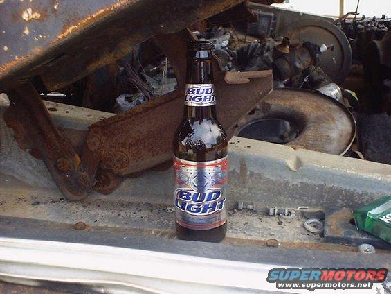 Engine bay with a Bud Light bottle and Supermotors.net logo