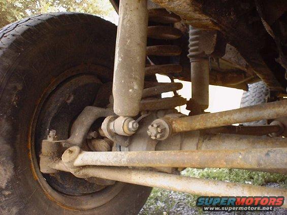 Close-up of rusty front suspension components and tire