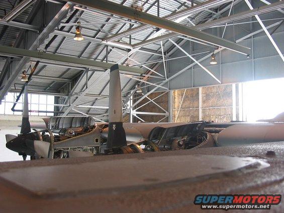 Airplane interior with exposed engines and propellers inside a hangar