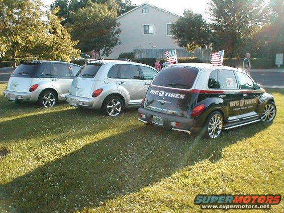 Three Chrysler PT Cruisers parked on grass, one black with 'BIG O TIRES' branding