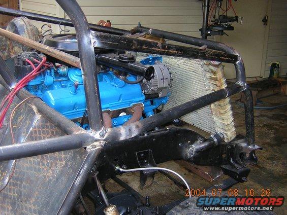 Custom off-road vehicle chassis with blue engine, radiator, and roll cage. Visible date stamp 2004