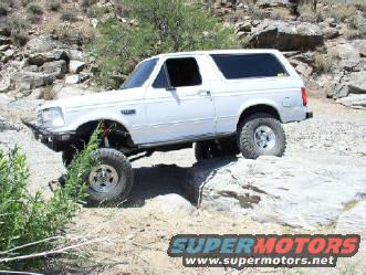 White Ford Bronco on rocks, looks like it's off-roading