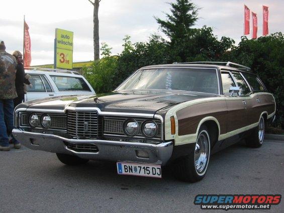 Station wagon with wood paneling, chrome bumper, and whitewall tires, parked outdoors