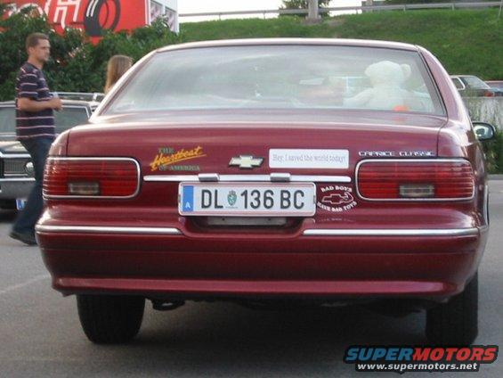 Rear of red Chevrolet Caprice Classic sedan with license plate DL 136 BC and various stickers