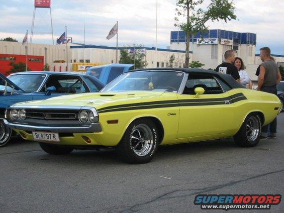 Yellow 1970 Dodge Challenger convertible with black stripes, front 3/4 view, parked outdoors