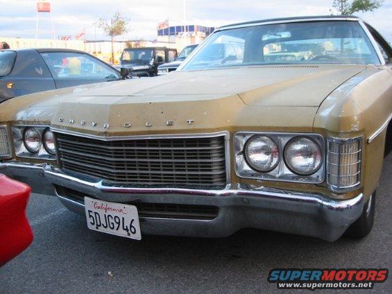 Gold Chevrolet sedan front end with chrome grille and dual headlights. California license plate 5DJG946
