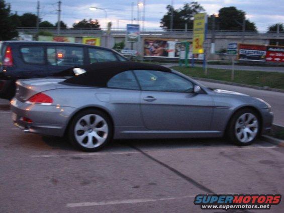 Silver convertible parked, black top up