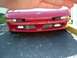 1992 Ford Probe - The front of a red 1992 Ford Probe is visible, with a hand partially covering the view from above.