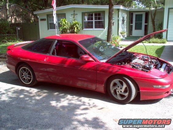 Red coupe with hood open, showing engine detail