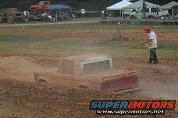 1989 Ford Bronco partially submerged in mud