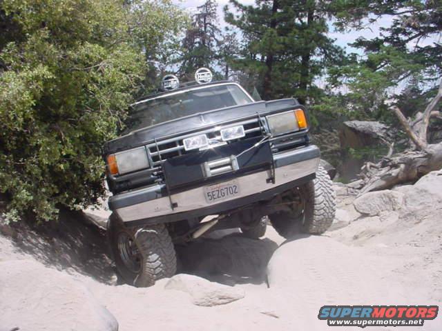 Black SUV with off-road tires navigating a rocky trail