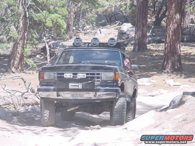 Black 1988 Ford Bronco driving on a rocky trail