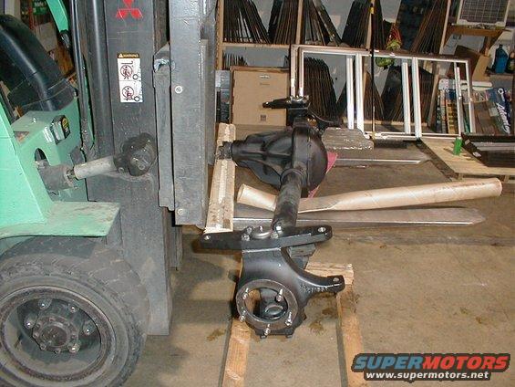 Forklift moving a vehicle axle assembly