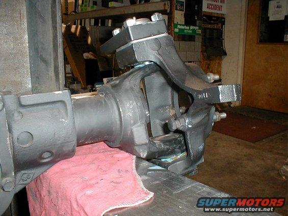 Front axle assembly clamped in a vise, showing suspension components