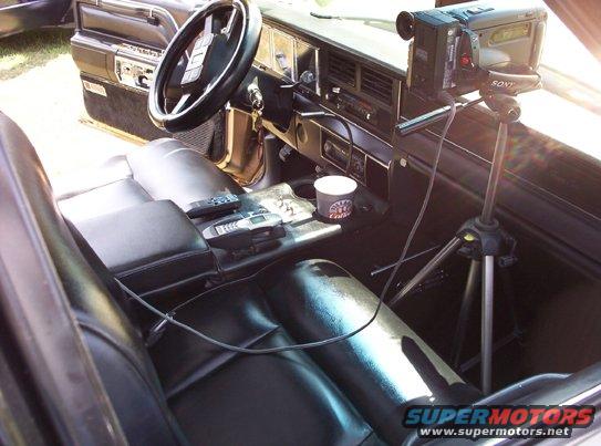 Interior view of a 1991 Ford Crown Victoria LTD, showing the dashboard, seats, and a Sony camcorder on a tripod